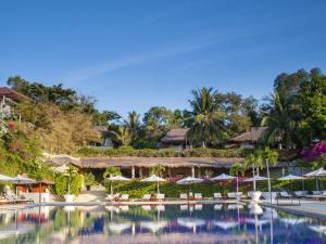 una piscina en un complejo con sombrillas y sillas en Victoria Phan Thiet Beach Resort & Spa, en Mui Ne