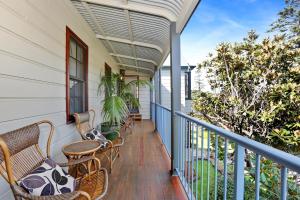 a balcony with chairs and tables on a house at Bellevue Accommodation in Kiama
