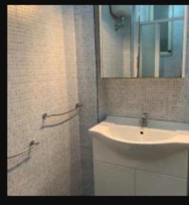 een badkamer met een wastafel, een spiegel en een douche bij Casa Vacanza Rosanna in Torre Lapillo