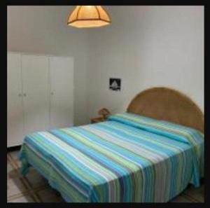 a bedroom with a bed with a striped blanket on it at Casa Vacanza Rosanna in Torre Lapillo