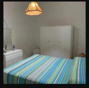 a bedroom with a bed with a colorful striped sheets at Casa Vacanza Rosanna in Torre Lapillo