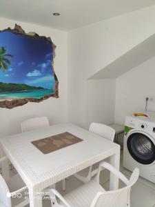 een witte tafel en stoelen in een kamer met een wasmachine bij Cala Blanca 85 in Jávea