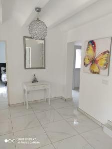 Habitación blanca con una foto de una mariposa en la pared en Cala Blanca 85, en Jávea