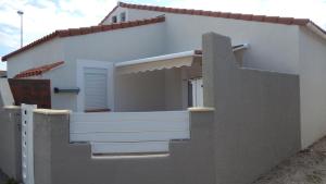 a white house with a balcony and a fence at Marendes Des Palombes 2 in Le Barcarès
