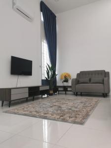 sala de estar con sofá y TV en Damai Homestay Alor Setar en Alor Setar