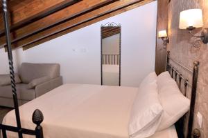 - une chambre avec un lit, une chaise et un miroir dans l'établissement Alojamiento Colmenar de Oreja Plaza Mayor, à Colmenar de Oreja