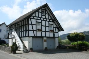 a black and white house with a garage at Ferienhaus Zur Ennest in Schmallenberg