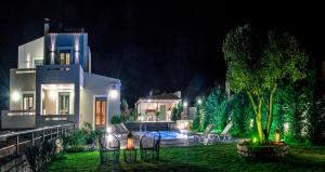 a white house with a yard at night at Villa Horizon in Skouloúfia
