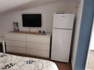 a kitchen with a white refrigerator and a tv at villa peppino in Montallegro