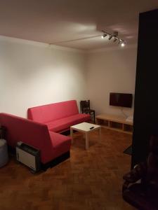 a living room with a red couch and a tv at Hotell Kong Christian in Kristianstad