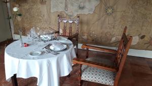 a table with a white table cloth and two chairs at Parador de Ferrol in Ferrol