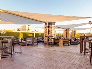 eine Terrasse mit Tischen und Stühlen unter einem Baldachin in der Unterkunft Novotel Madrid Center in Madrid