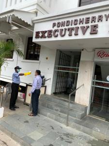un par de personas parados fuera de un edificio en Pondicherry Executive Inn, en Pondicherry