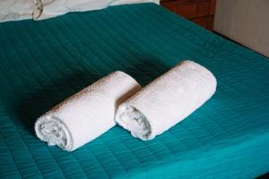 2 rouleaux de serviettes en papier assises sur un lit dans l'établissement Casas de Pedra - Quinta da Escola, à Alvados