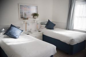 two beds sitting next to each other in a room at Beachlands Hotel in Weston-super-Mare