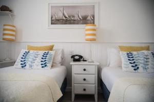 a bedroom with two beds and a picture on the wall at Beachlands Hotel in Weston-super-Mare