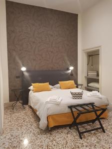1 dormitorio con 1 cama grande con almohadas amarillas en MammaDada charm rooms, en Bari