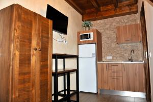 a small kitchen with a white refrigerator and a counter at Alojamiento Colmenar de Oreja Plaza Mayor in Colmenar de Oreja