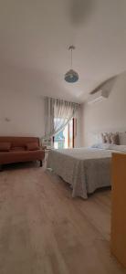 ein großes Schlafzimmer mit einem Bett und einem Sofa in der Unterkunft B&B Belvedere Castelluccio Valmaggiore in Castelluccio Valmaggiore