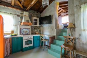 a kitchen with blue cabinets and stairs in a house at Ta Petrina in Vourvourou