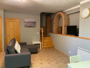 a living room with a couch and a clock on the wall at Casa MARIA VILLARROYA in Villarroya