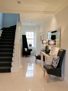 sala de estar con escalera y 2 sillas en Glangwili Mansion - Luxury 5 star Bed & Breakfast, en Carmarthen