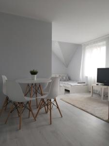 a white living room with a table and chairs at Willa Ela in Gdańsk