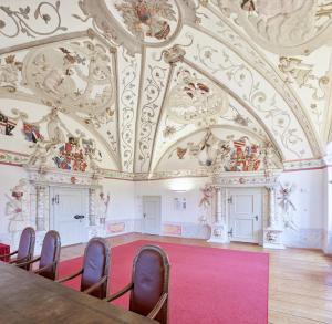 a room with a table and chairs and a ceiling at Schloss Weinberg in Kefermarkt