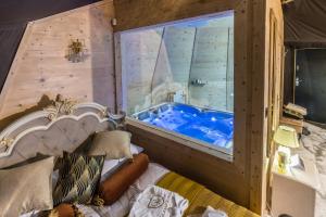 ein Schlafzimmer mit einem Bett und einer Badewanne in einem Zimmer in der Unterkunft Glamp Royal in Biały Dunajec