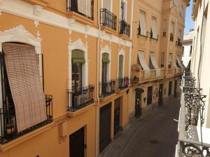 un callejón en un edificio con balcones en Corredera Rooms, en Córdoba