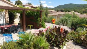 un patio con mesa, sillas y plantas en Villa Les hauts de Benista en Porticcio