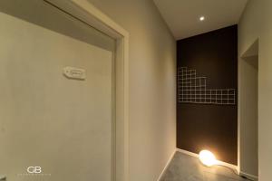 La salle de bains est pourvue d'une porte et d'une lumière sur le mur. dans l'établissement Palazzo al Carmine Dimora Storica, à Castelvetrano