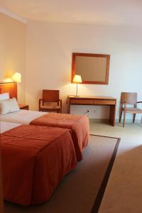 um quarto de hotel com duas camas e uma secretária em Vista Marina Apartamentos Turisticos em Portimão