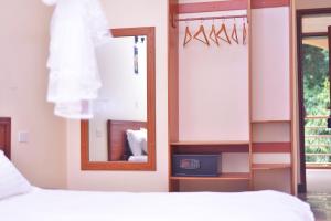 Nabisere Hotel Kalisizo في Kalisizo: غرفة نوم بسرير ومرآة ومرآة