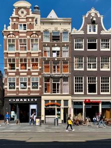 un grande edificio con persone che camminano davanti di Hotel Damrak Inn ad Amsterdam