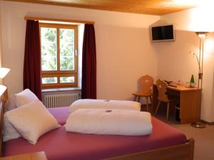 1 Schlafzimmer mit 2 Betten, einem Schreibtisch und einem Fenster in der Unterkunft Hotel Preda Kulm in Bergün