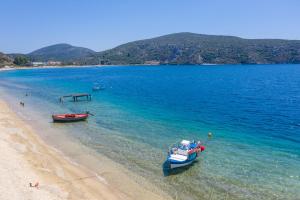 two boats in the water on a beach at Notia Luxury Living in Porto Koufo