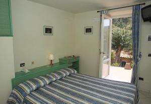 a bedroom with a bed and a sliding glass door at Hotel Danila in Portoferraio