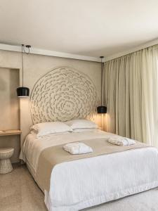 a bedroom with a large bed with a large headboard at Mimi and Coco Villas Corfu in Paramonas