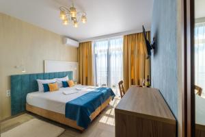 a bedroom with a bed and a wooden table at Na Chernomorskoy Hotel in Feodosia