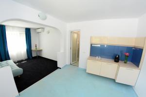 Habitación grande con cocina azul y blanca en Apartamente Liliacul, en Jupiter