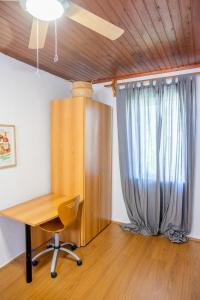 una oficina con escritorio de madera y ventana en Cozy House with Flowery Courtyard in Notable Location, en Rodas