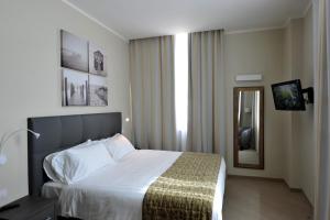 a hotel room with a bed and a mirror at CHC Business Residence in Genova