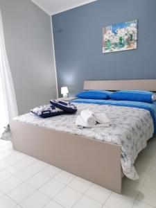 a bed with blue pillows and towels on it at Ranieli Apartments in Drapia