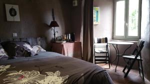 a bedroom with a bed and a table and chairs at Coeur d'Aubrac in Recoules-dʼAubrac