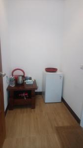 a room with a small refrigerator and a table at Jinsha Haiyunbian I Homestay in Nangan