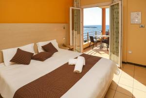 Schlafzimmer mit einem Bett und Meerblick in der Unterkunft Janus Hotel in Castelsardo