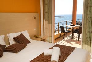 Schlafzimmer mit einem Bett und Meerblick in der Unterkunft Janus Hotel in Castelsardo