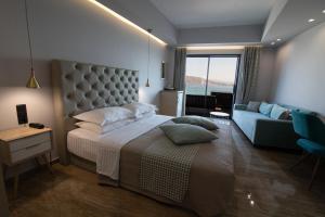 a hotel room with a bed, chair and a television at Aianteion Bay Luxury Hotel & Suites in Aiándion