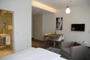 a bedroom with a bed and a table with a chair at Boardinghouse Offenbach Service Apartments in Offenbach